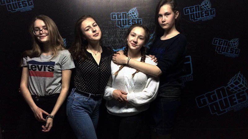 Four girls pose in front of the camera after finishing an escape quest.